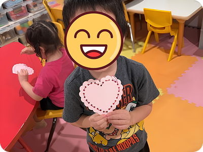 Child holding a heart craft